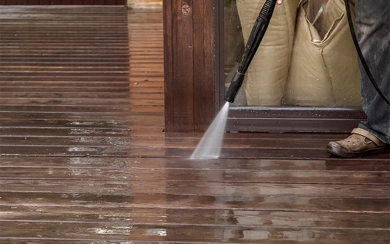 man taking care of hardwood with pressure washing