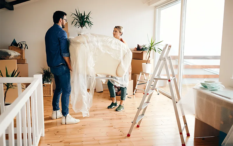 couple moving house, in a hardwood room, with boxes all around